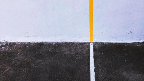 yellow line on wall meeting white line on black pavement