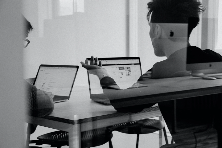 Two business leaders sitting in an office talking through the needs of their business