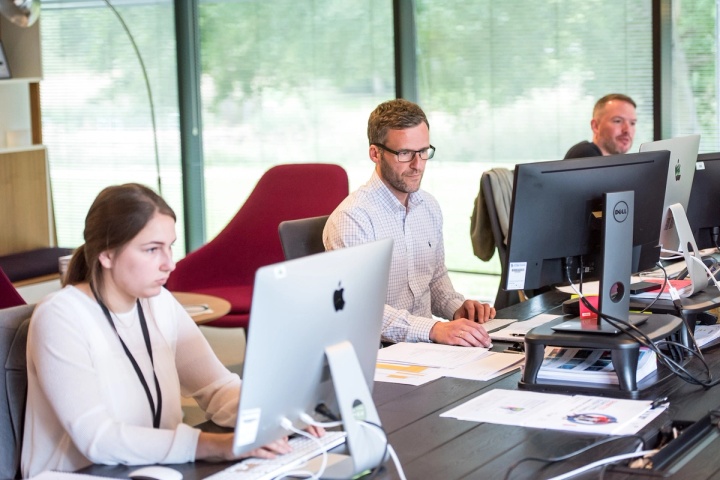 Woman and man on computers in an office providing live chat support