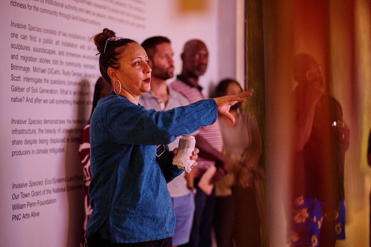 Photo courtesy of Albert Yee. Person standing in the exhibit pointing.