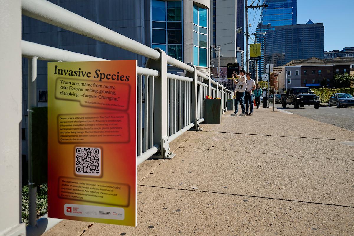 Photo courtesy of Albert Yee. 2 People taking photos over the bridge with Invasive Species sign half in the picture. .
