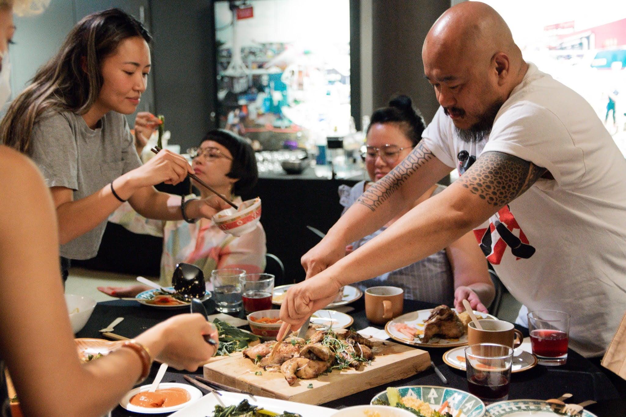 A chef cutting meat for a table full of people