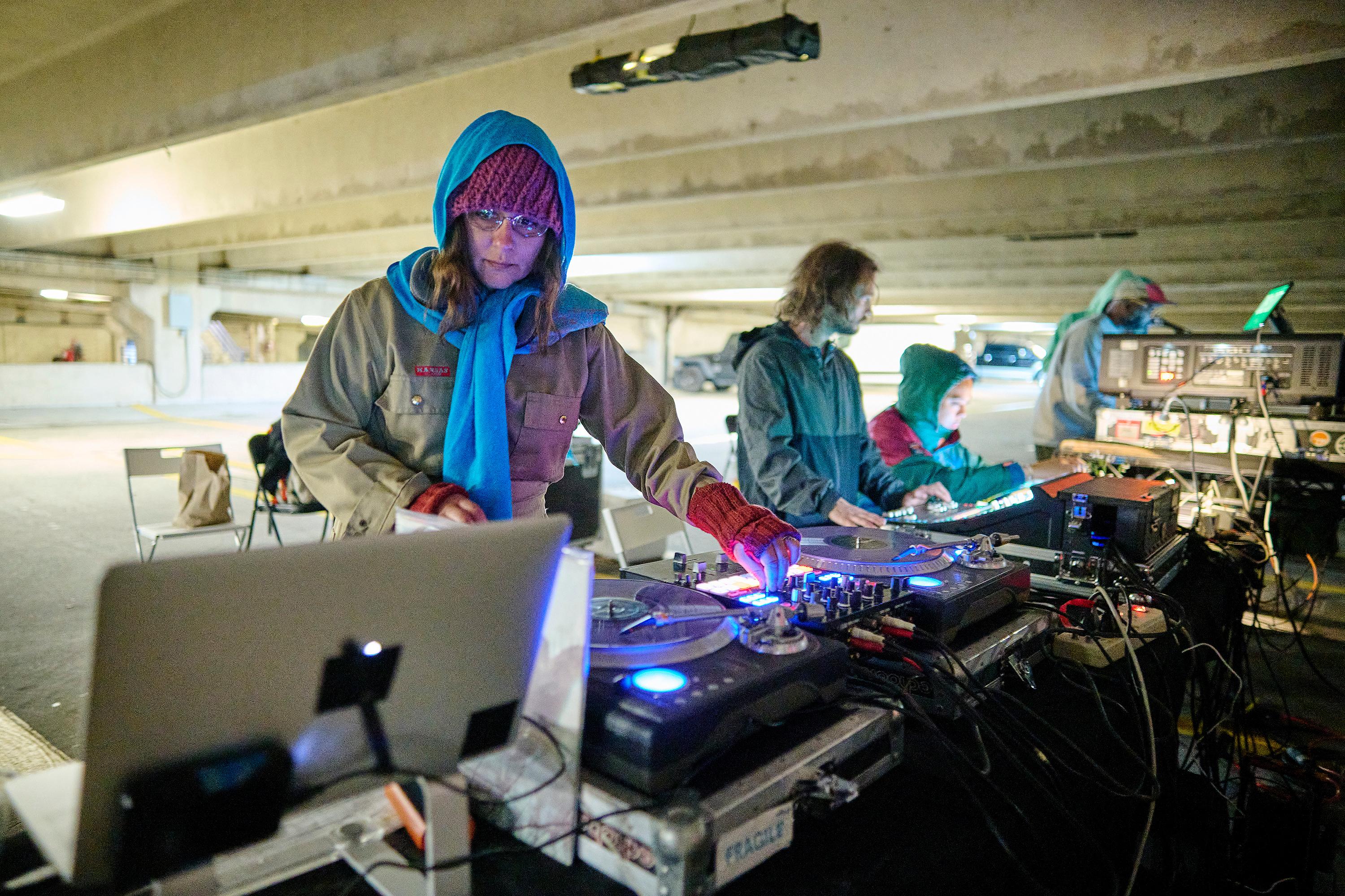 Photo courtesy of Albert Yee. Person working a DJ board and other working equipment in a parking garage.