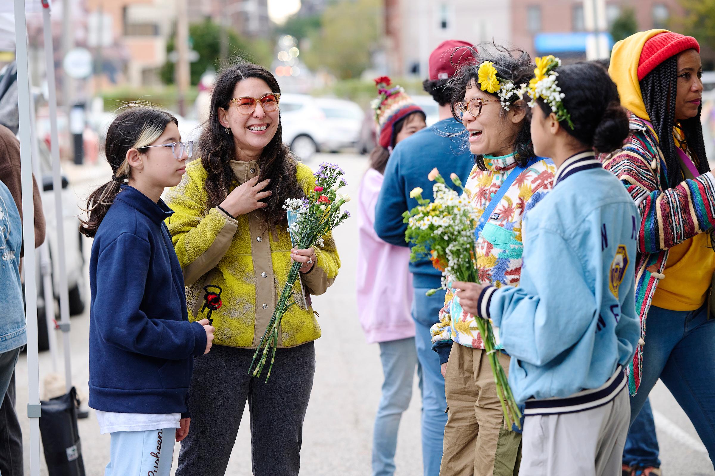 Photo courtesy of Albert Yee. People at Block Party holding flower bouquets and wearing flower crowns.