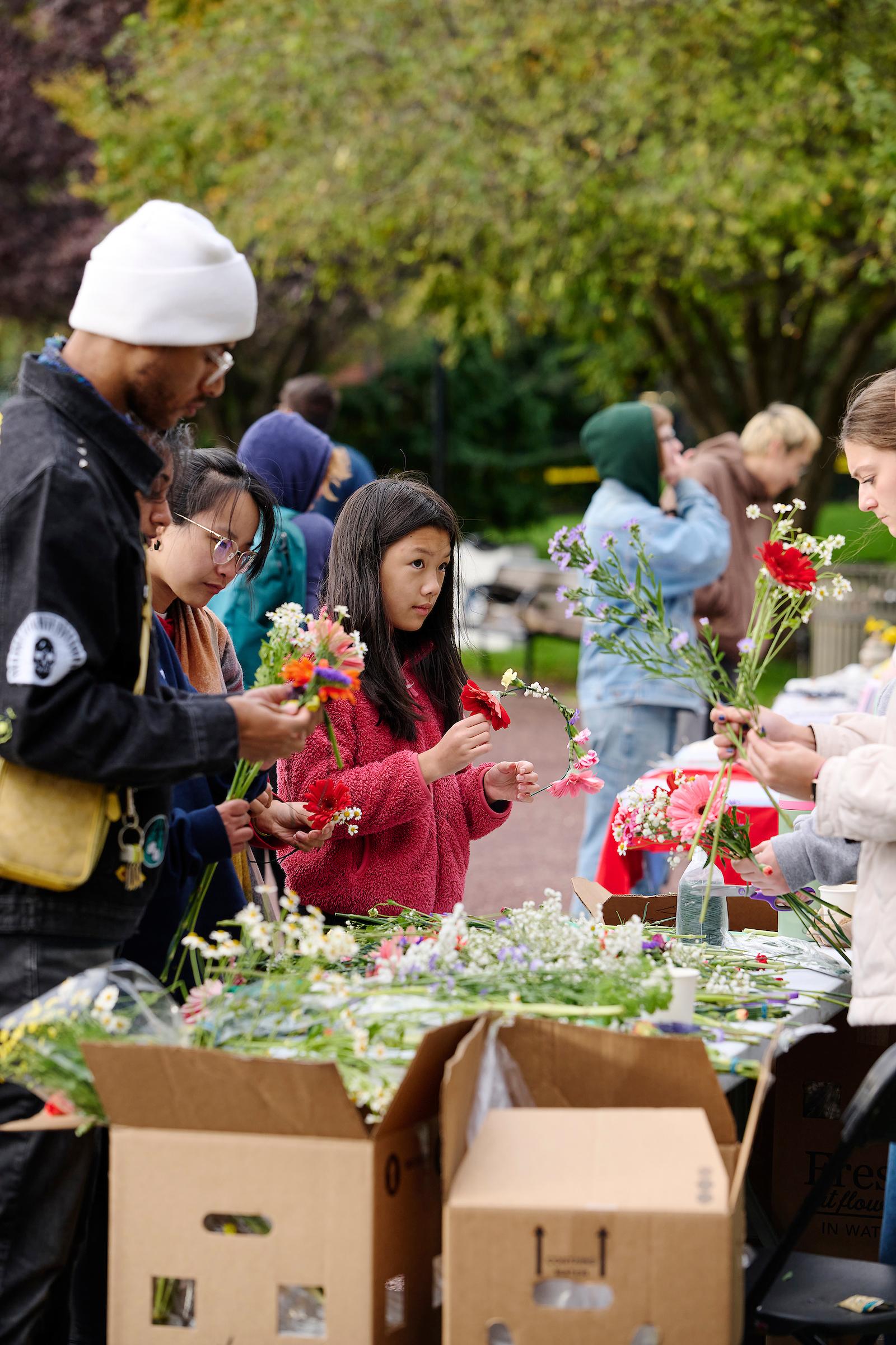 Photo courtesy of Albert Yee. People making flower crowns and holding flowers.