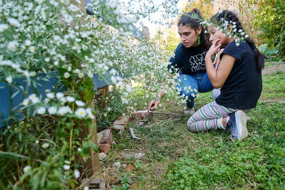 Photo courtesy of Albert Yee. AAI Education teacher showing student flowers in the garden.