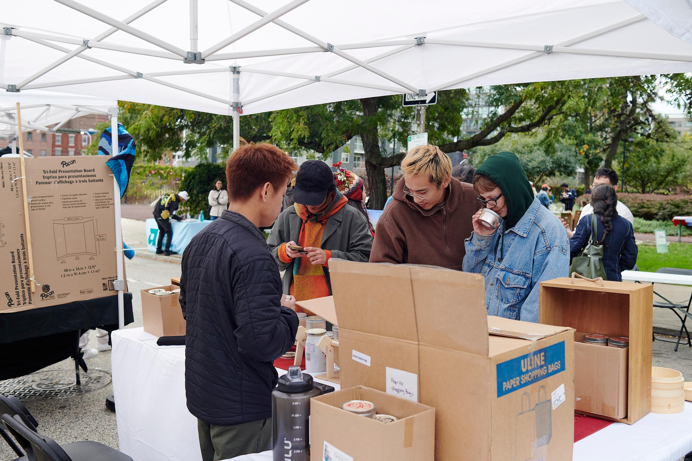 Photo courtesy of Albert Yee. People smell and look at candles at vendors booth.