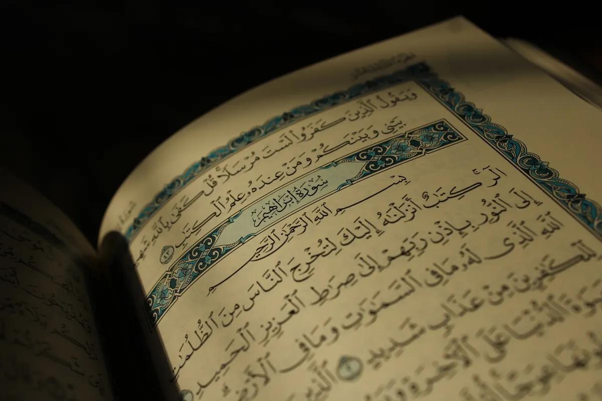 مصحف مفتوح مع جدول حفظ جزء عم ورقية