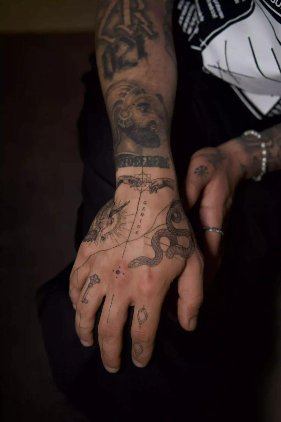 Mikrorealismus-Komposition als Tattoo an der Hand