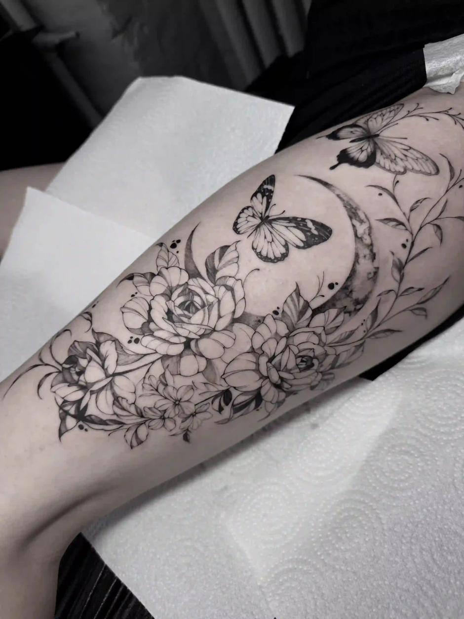 Schwarz-Grau-Fineline-Tattoo mit Rosen, Schmetterlingen und Mondsichel am Bein