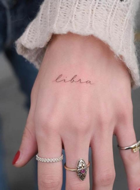 Fineline-Lettering-Tattoo an der Hand