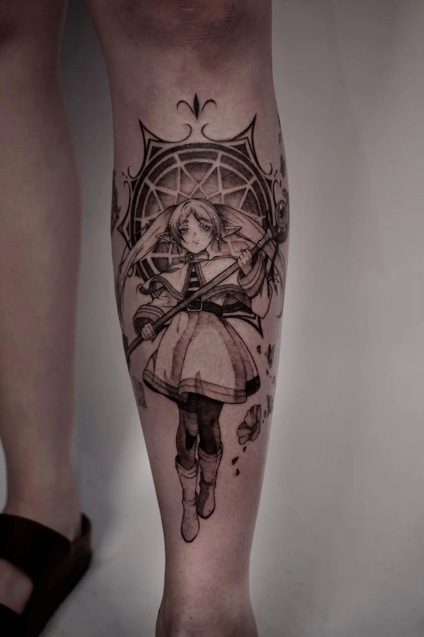 Anime-inspiriertes Charakter-Tattoo einer jungen Magierin mit Stab vor einem geometrischen Kreismuster mit ornamentalen Details in Schwarz-Grau.