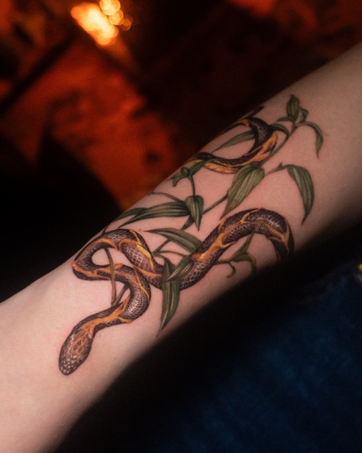 Farb-Mikrorealismus-Tattoo einer Schlange mit goldener Pflanze