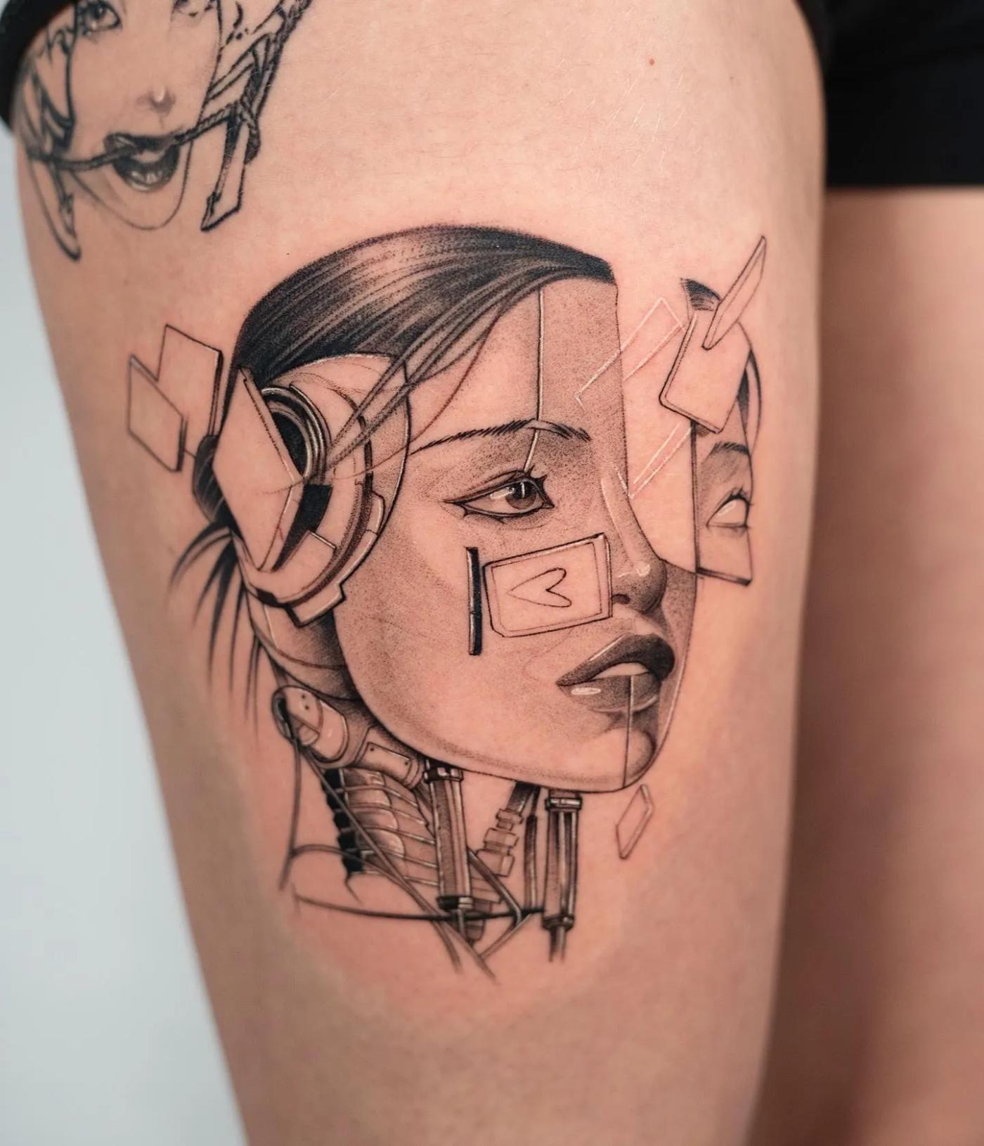 Cyberpunk-inspiriertes Tattoo eines weiblichen Android-Kopfes mit mechanischem Hals und schwebenden geometrischen Flächen, in Fineline und weicher Schattierung am Oberschenkel.