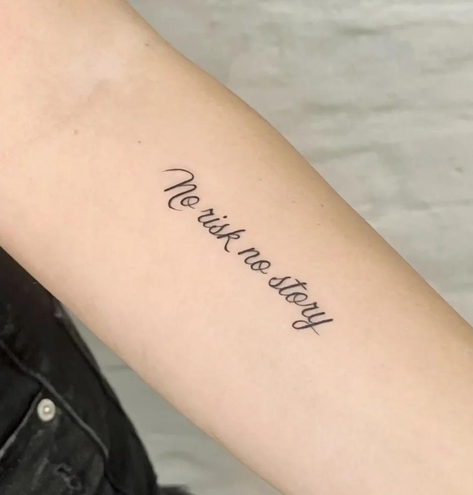 Fineline-Lettering-Tattoo mit dem Schriftzug 'No risk no story' am Unterarm