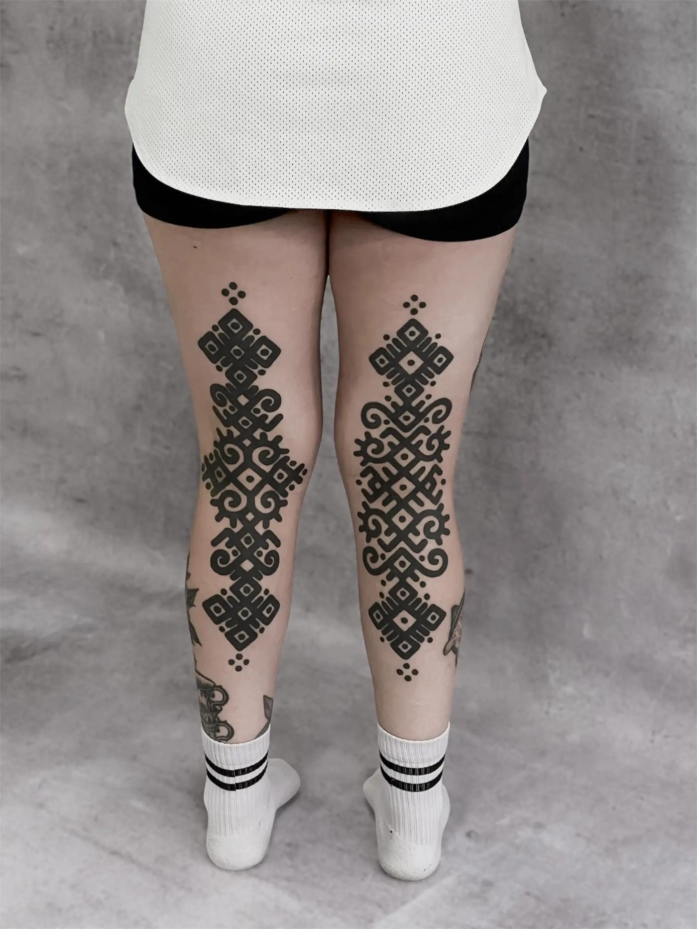 Kräftiges ornamentales Tattoo an den Beinen