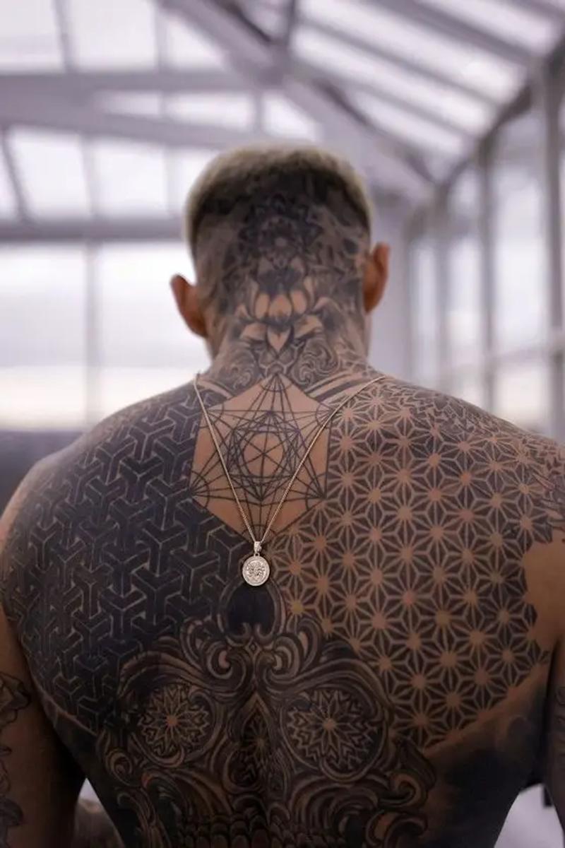Großflächiges Blackwork-Tattoo mit Mandala und heiliger Geometrie auf Rücken und Kopf