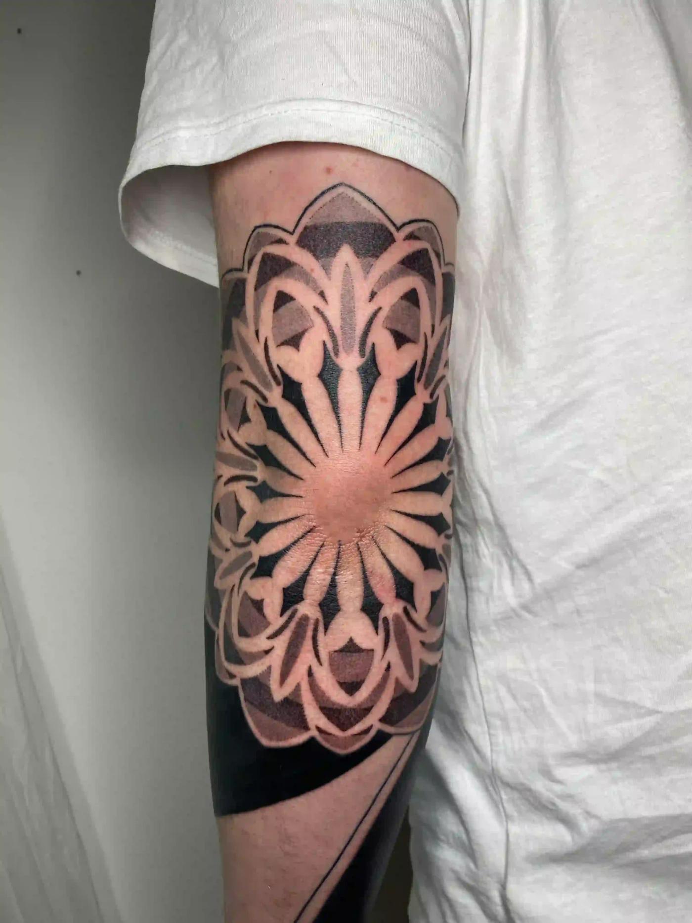Geometrisches Tattoo am Ellenbogen
