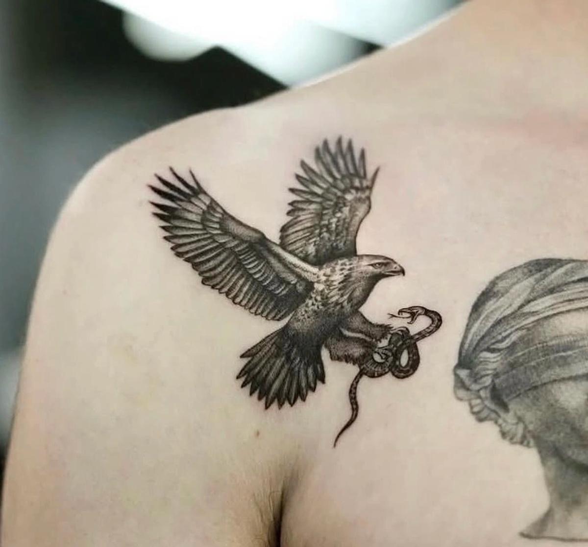 Black and grey microrealism tattoo of an eagle catching a snake