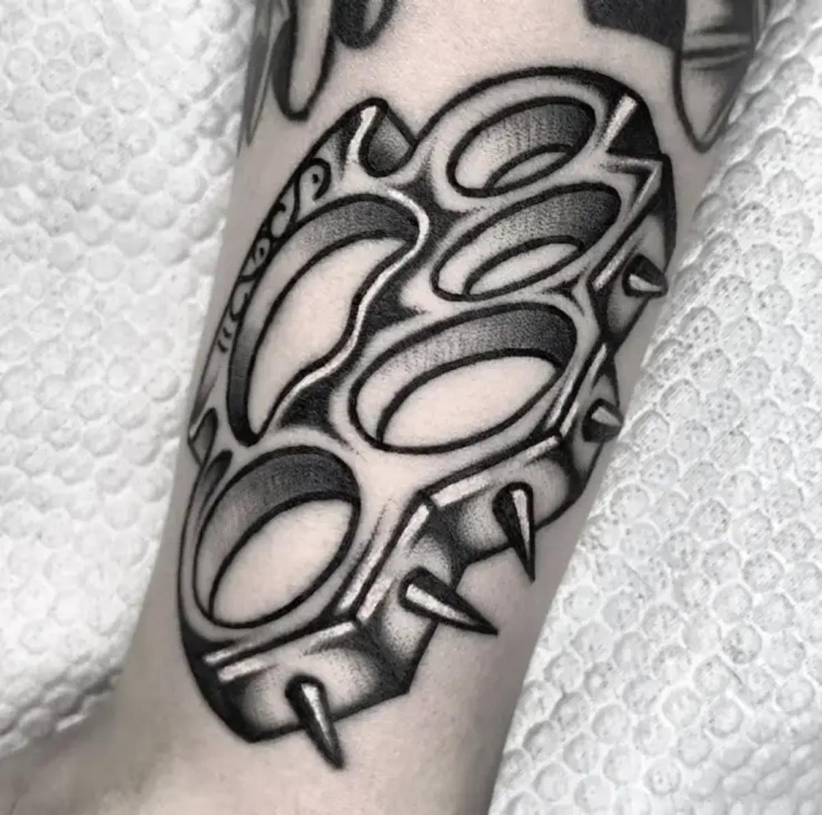 Traditionelles Schwarz-Weiß-Tattoo eines Schlagrings