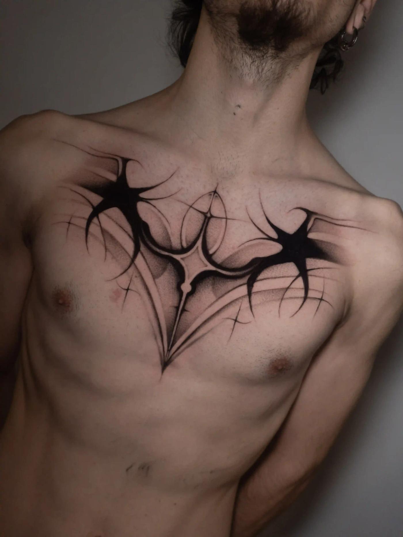 Abstraktes Blackwork-Tattoo über die Brust mit symmetrischen, spitzen Formen und weicher Verlaufsschattierung, das organischen Fluss und geometrische Präzision verbindet.
