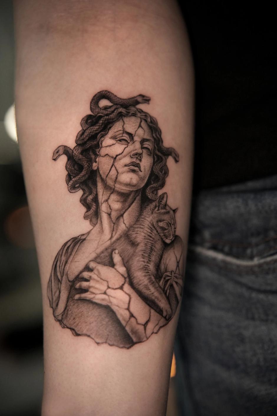 Microrealism forearm tattoo: Medusa as a cracked marble bust with snake hair, holding a sleeping cat