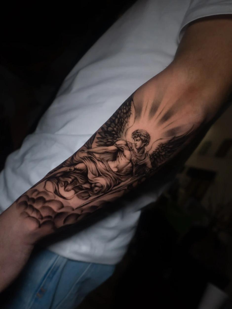 Schwarz-Grau-Realismus-Tattoo eines Engels mit Schwert, umgeben von Wolken und Lichtstrahlen, detailliert am Unterarm mit starkem Kontrast und weichen Verläufen.