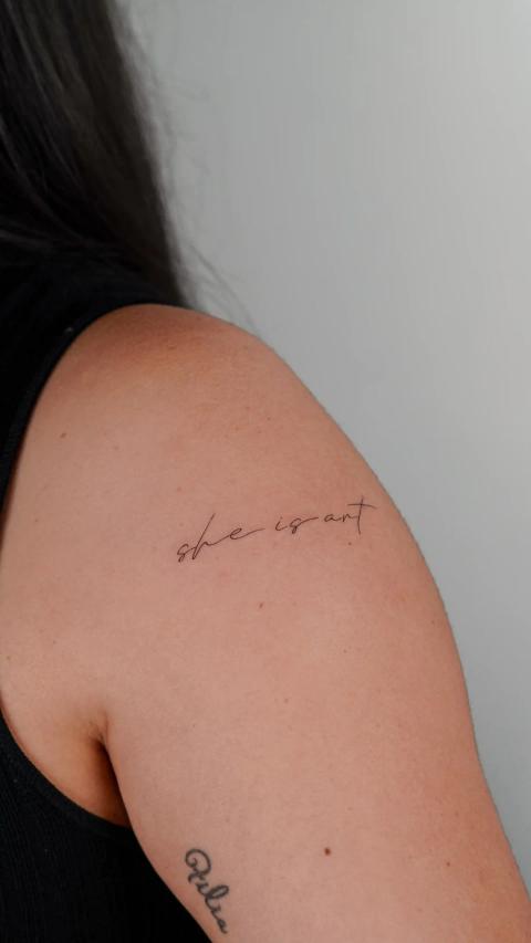 Fineline-Lettering-Tattoo mit dem Schriftzug "she is art"
