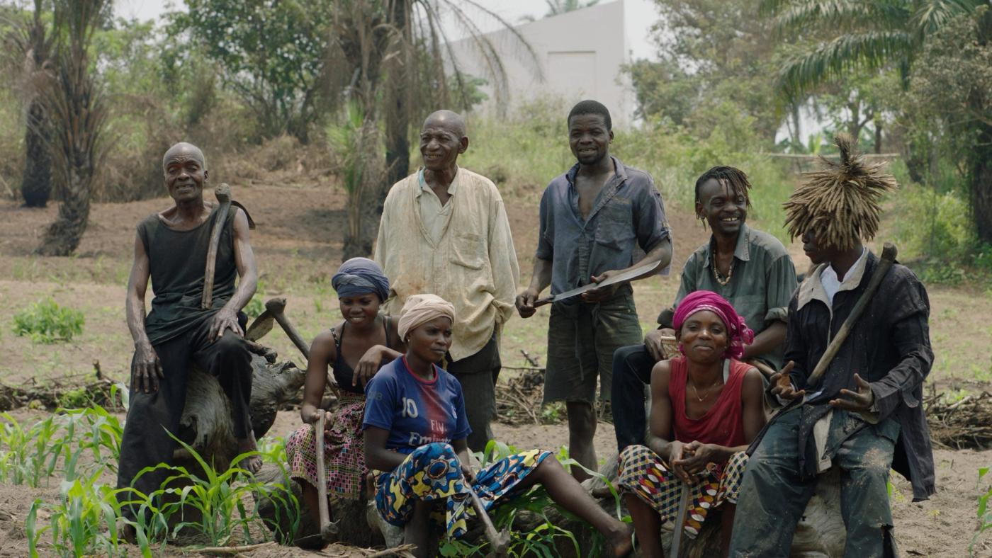 Mitglieder des Künstler*innenbundes Kongolesischer Plantagenarbeiter*innen (CAPTC) in Lusanga, Kongo. v.l.n.r.: Olele Mulela Mabamba, Irène Kanga, Huguette Kilembi, Jérémie Mabiala, Jean Kawata, Mbuku Kimpala, Ced’art Tamasala and Matthieu Kasiama. Film still from White Cube, Renzo Martens. Copyright © Human Activities, 2020.