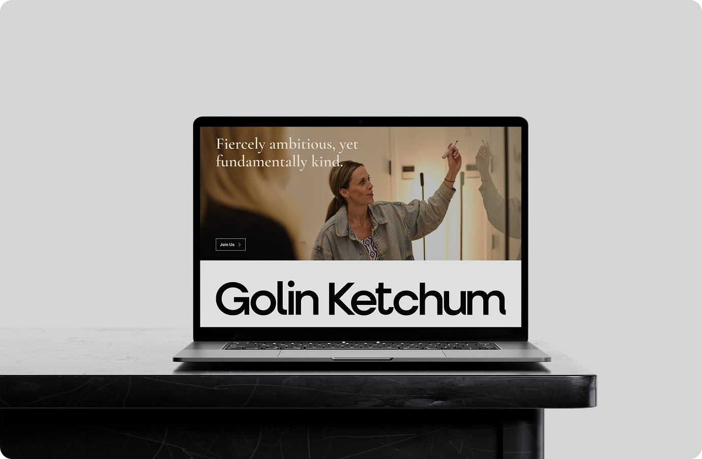A laptop screen showing Golin Ketchum homepage