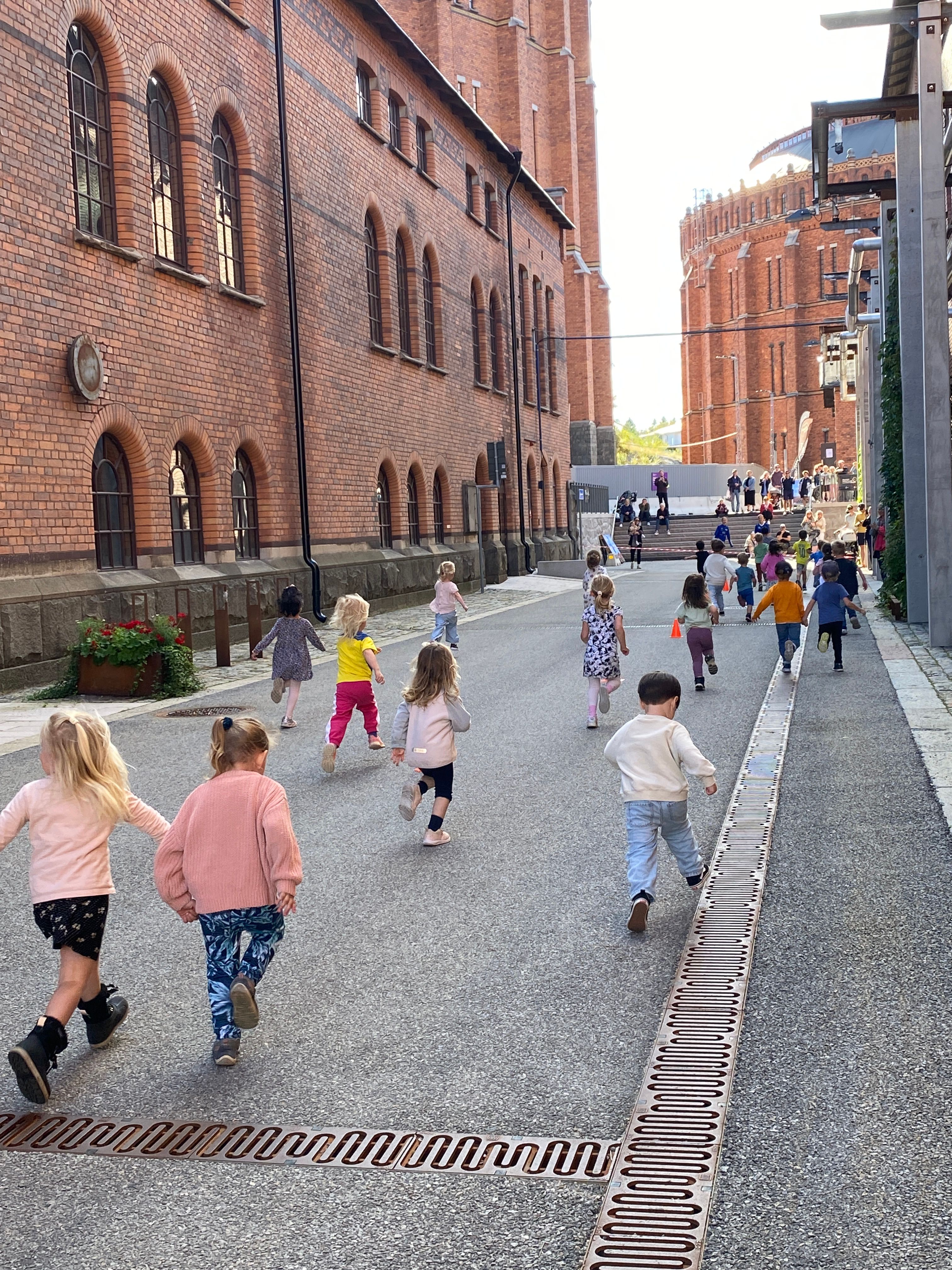 Barn deltar i Lilla Gasverksloppet längs den historiska tegelbyggnaden i Gasverksområdet.