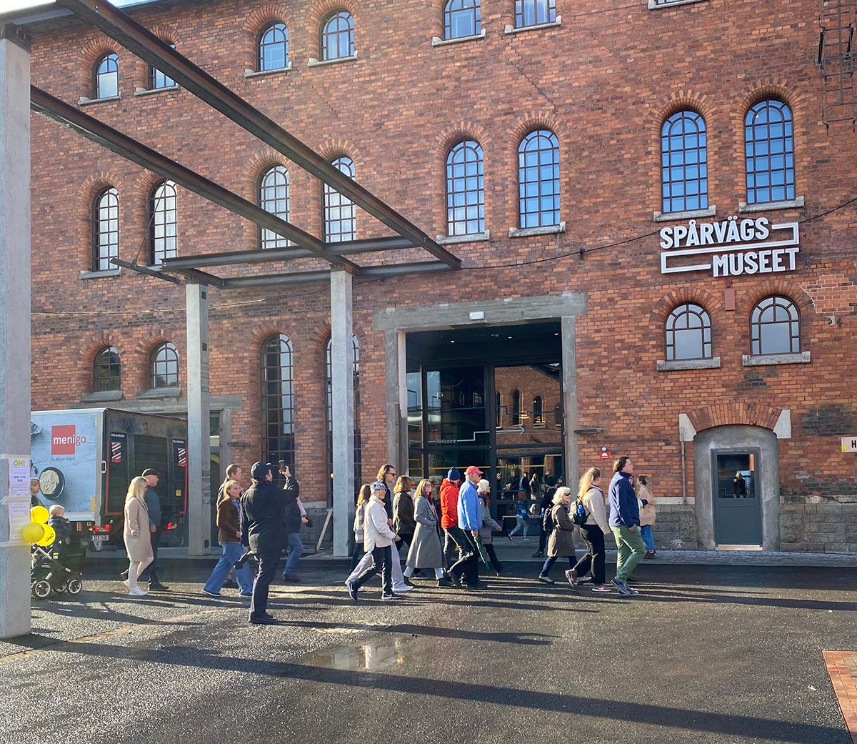 Spårvägsmuseets huvudentré i Gasverket. Folk promenerar förbi.