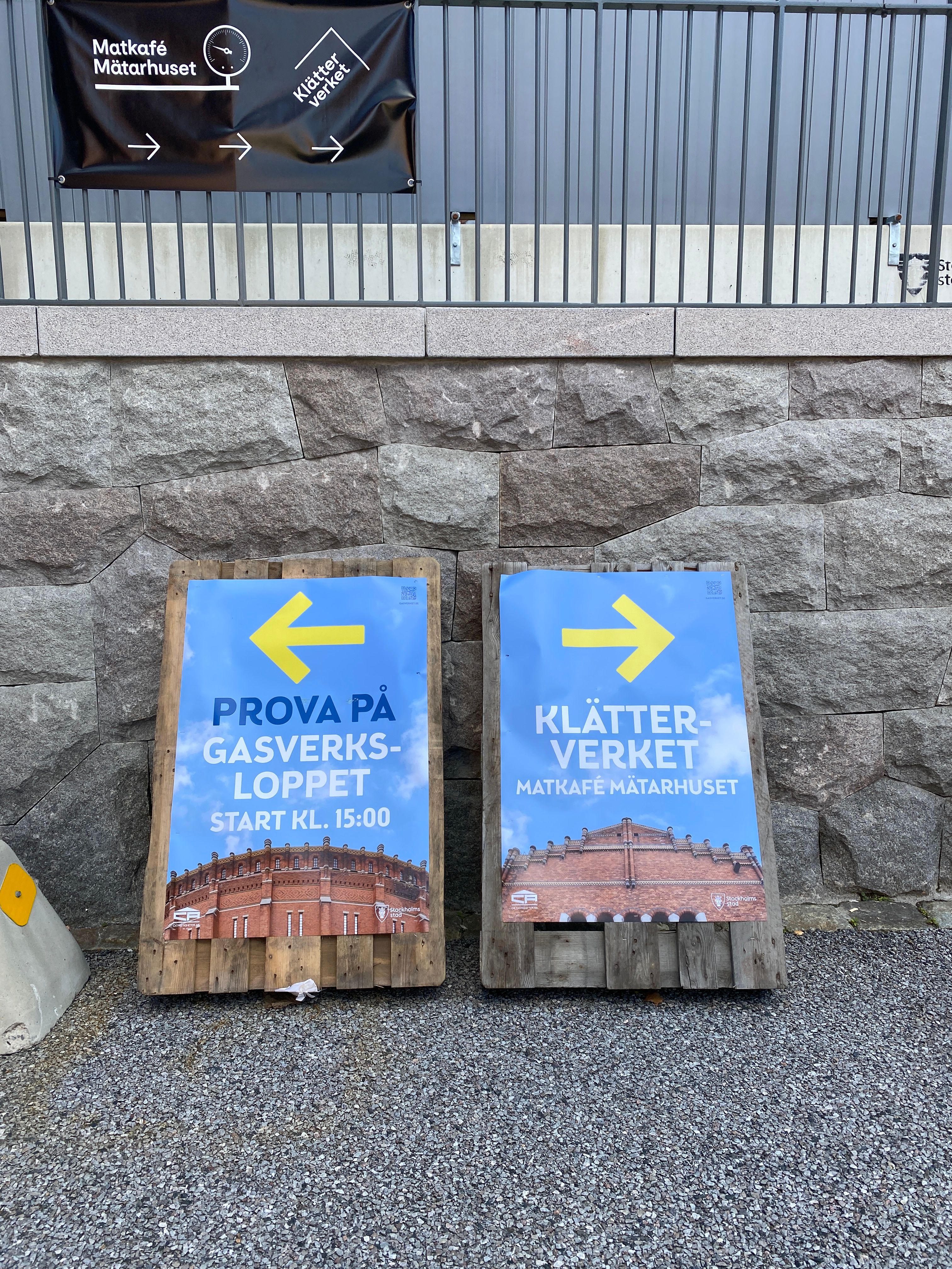 Vägvisande skyltar på Gasverksdagen som pekar mot Gasverksloppet och Klätterverket.