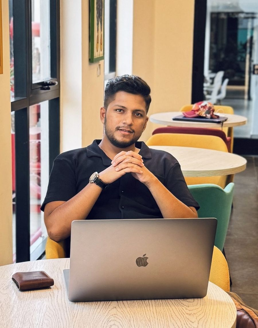 Abuzar Rafique working on a laptop in a cafe