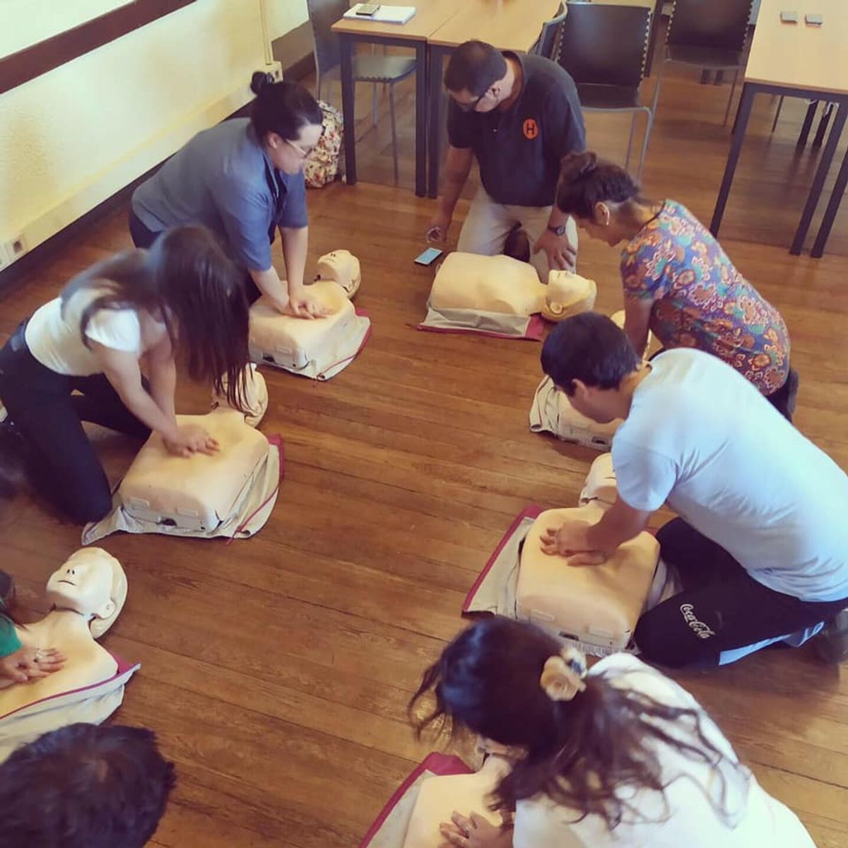 Participantes practican reanimación cardiopulmonar durante una capacitación.