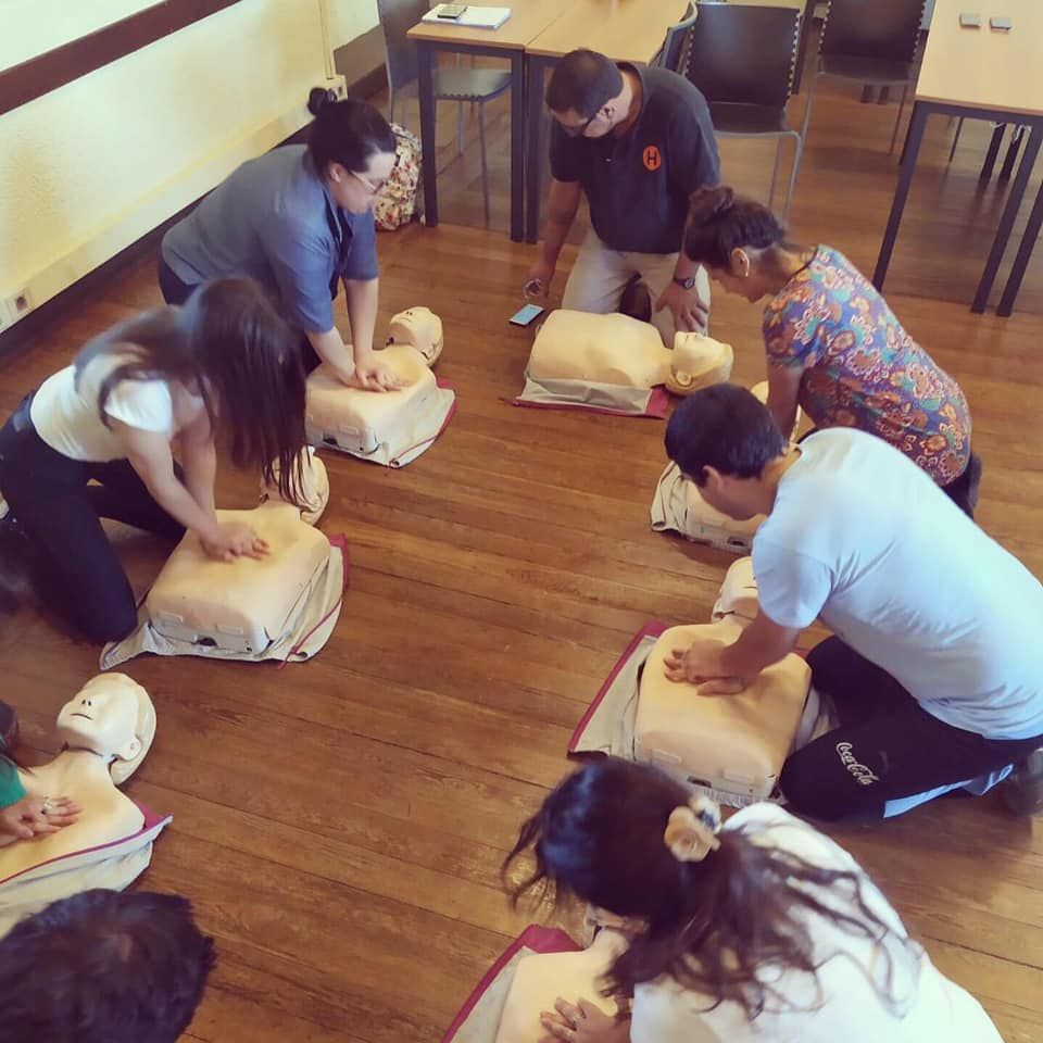 Participantes practican reanimación cardiopulmonar durante una capacitación.