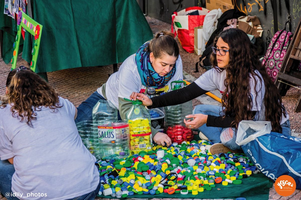Voluntarias clasifican tapitas plásticas para una iniciativa de reciclaje.