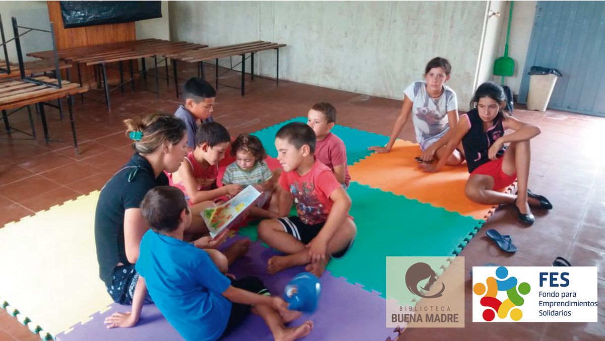 Voluntaria lee un cuento a un grupo de niños en un centro comunitario.