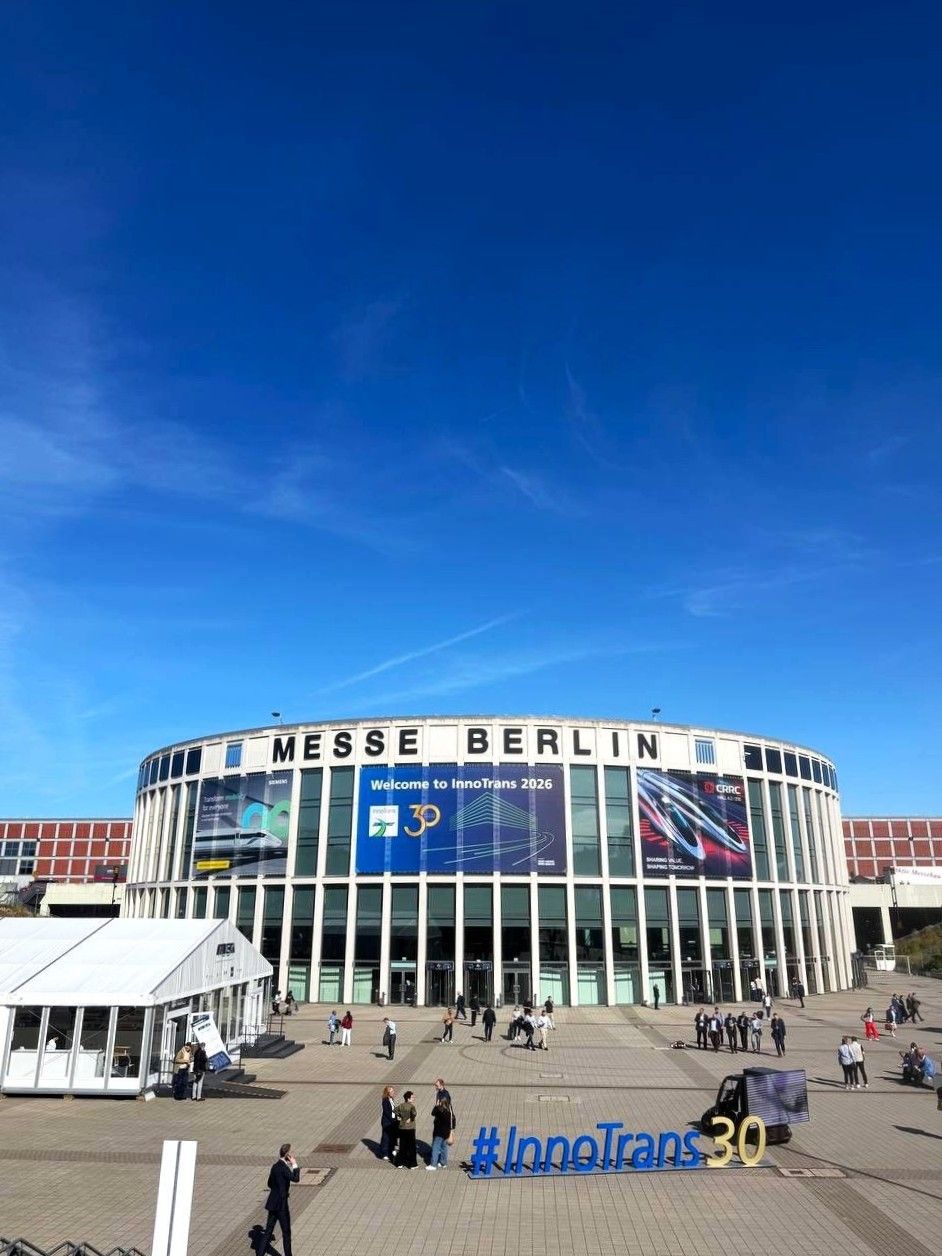 Exterior of Messe Berlin under a clear blue sky, with a “Welcome to InnoTrans 2026” banner and an #InnoTrans30 sign in the plaza.