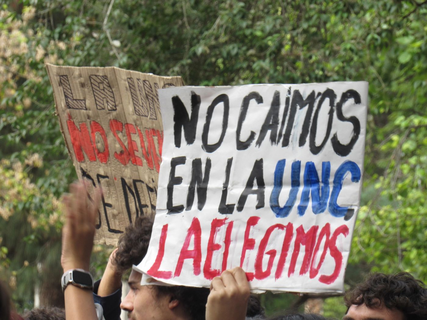 Estudiantes con un cartel que dice «No caímos en la UNC, la elegimos»
