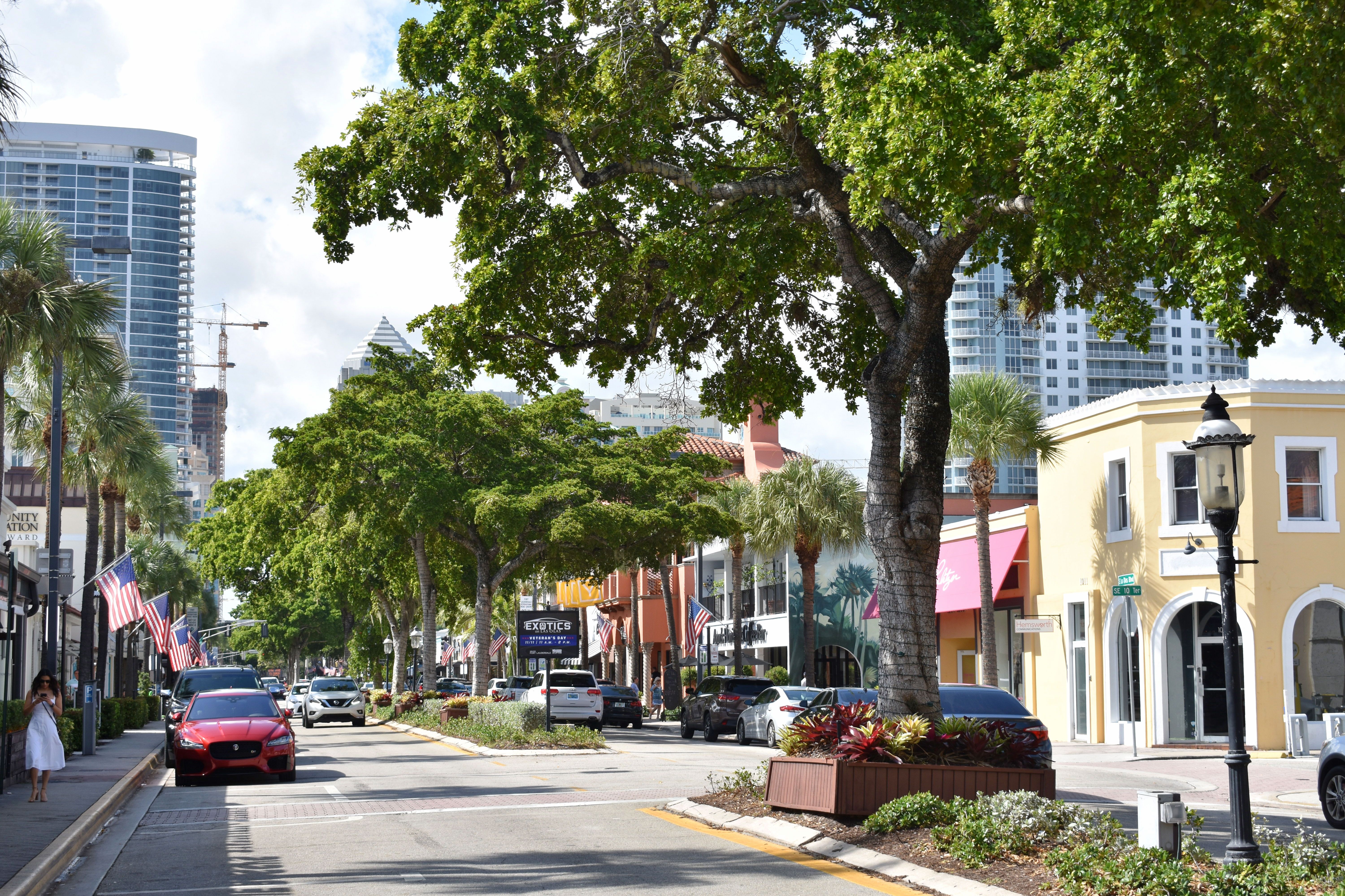 Tree-lined Las Olas Boulevard with restaurants and shops in a 2018 photograph; archival neighborhood context, not Naia.