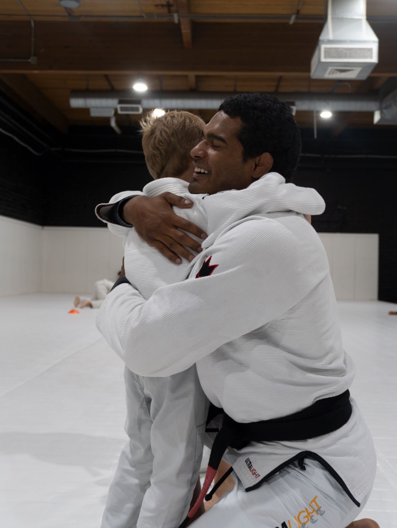 A coach hugging a student straight after his promotion