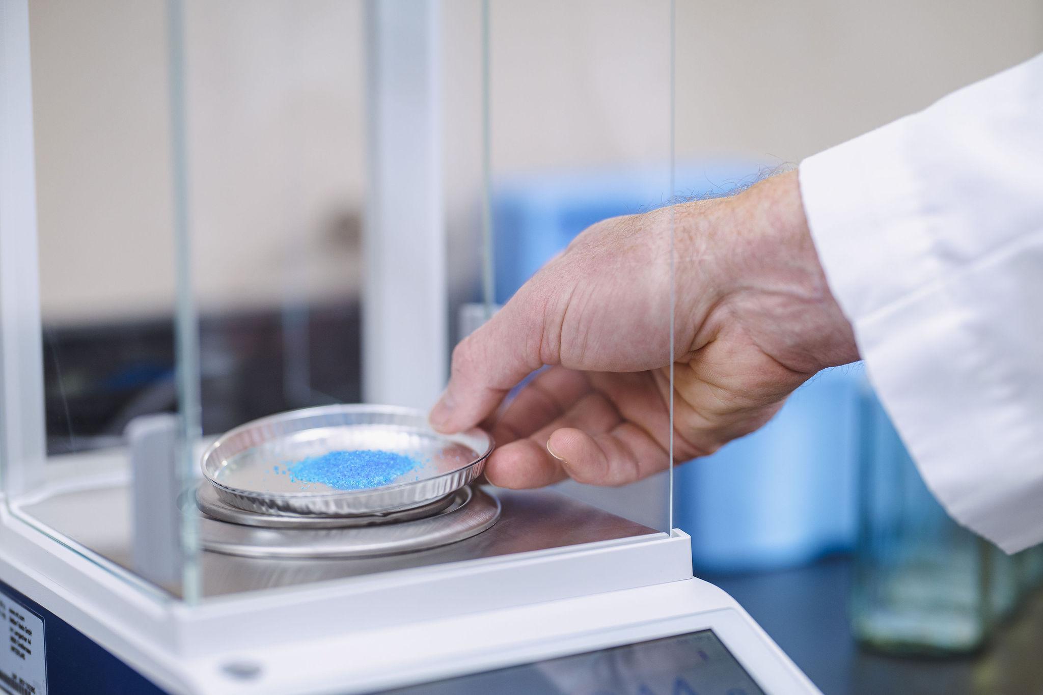 WSI scientist weighing chemical compounds in the lab — green chemistry innovation