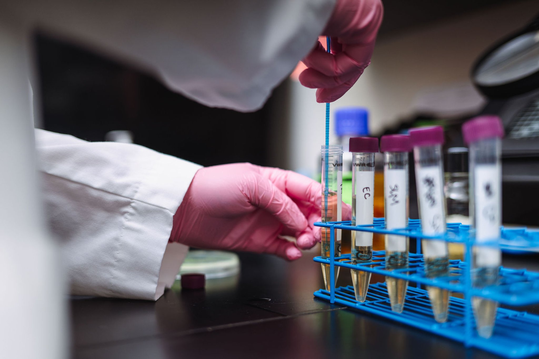 Lab technician handling test tubes with chemical samples
