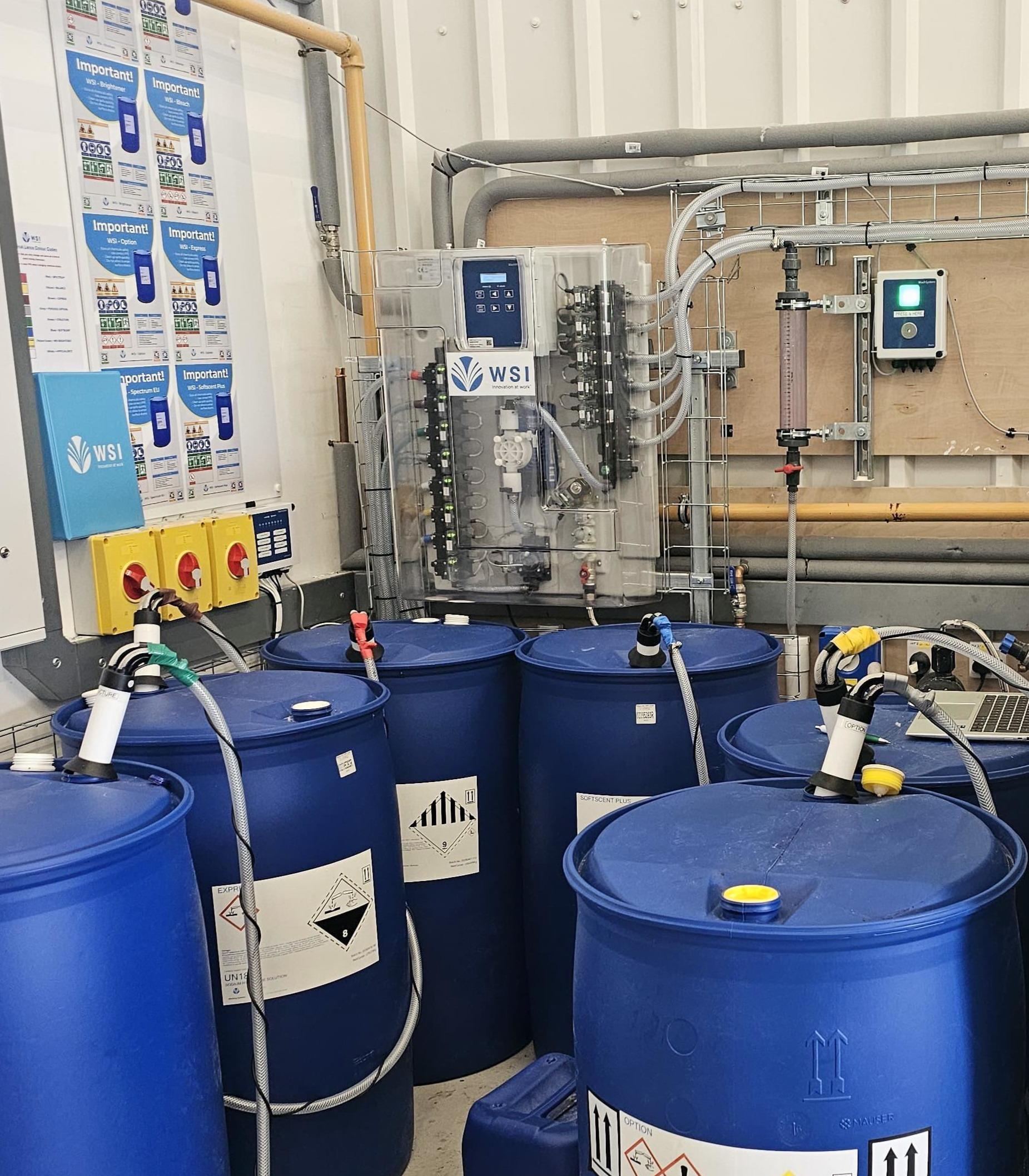 WSI chemical dosing panel with online monitoring, safety board and chemical drums installed at Guest Linen