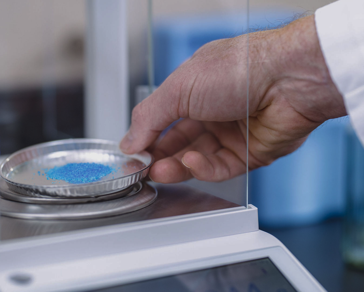 Blue powder chemistry sample on precision scale