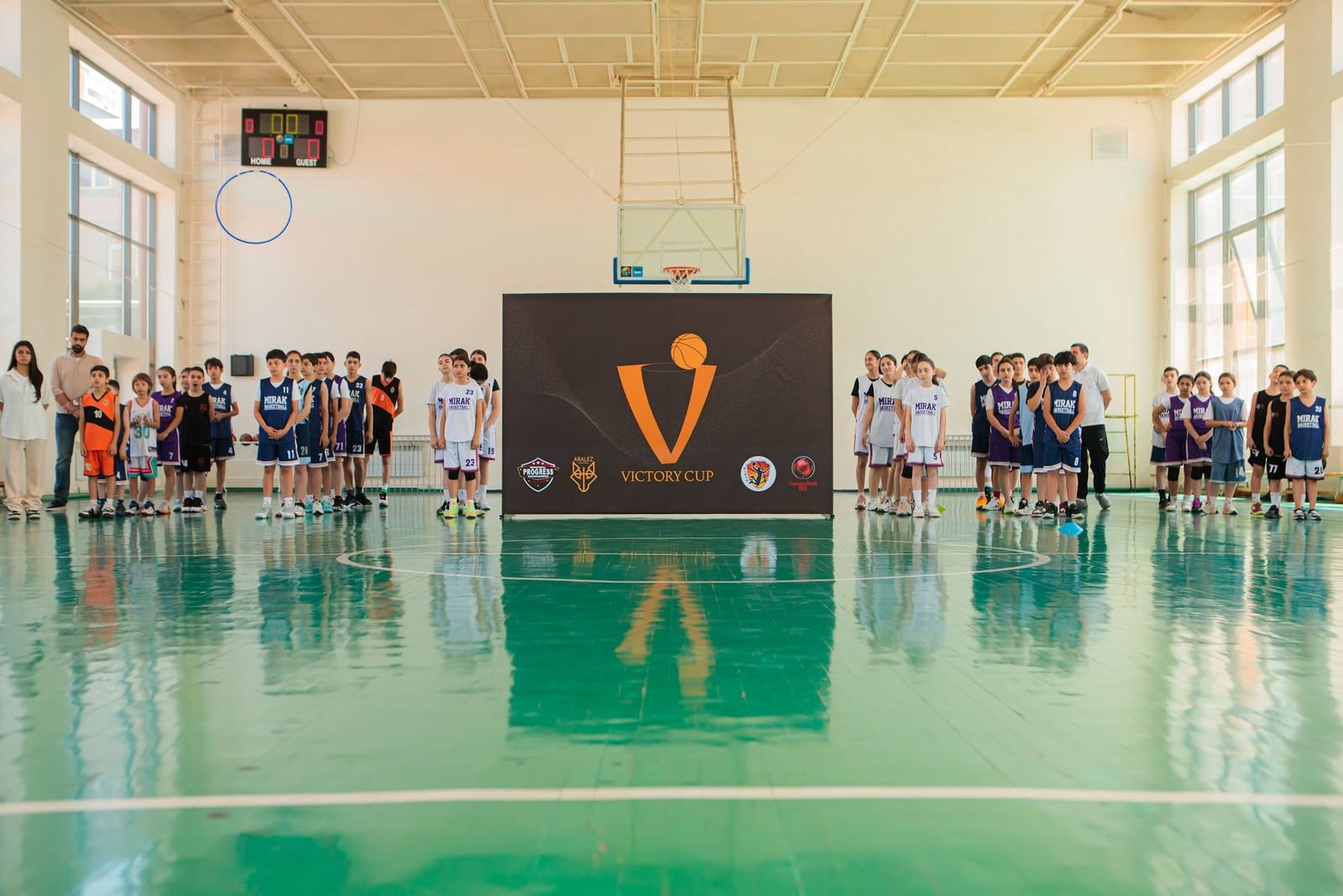 Teams beside the basketball tournament backdrop