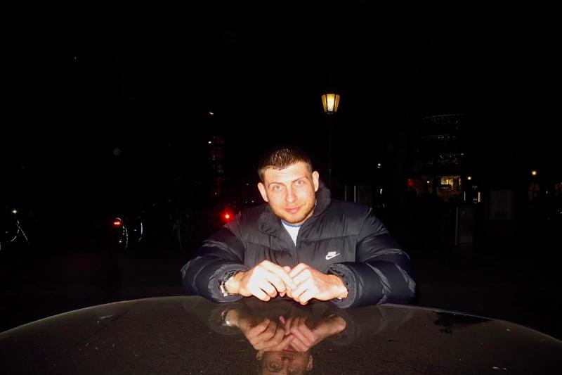 Patrik leaning against a car