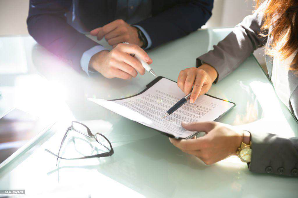 Two advisors reviewing an investment document at a desk