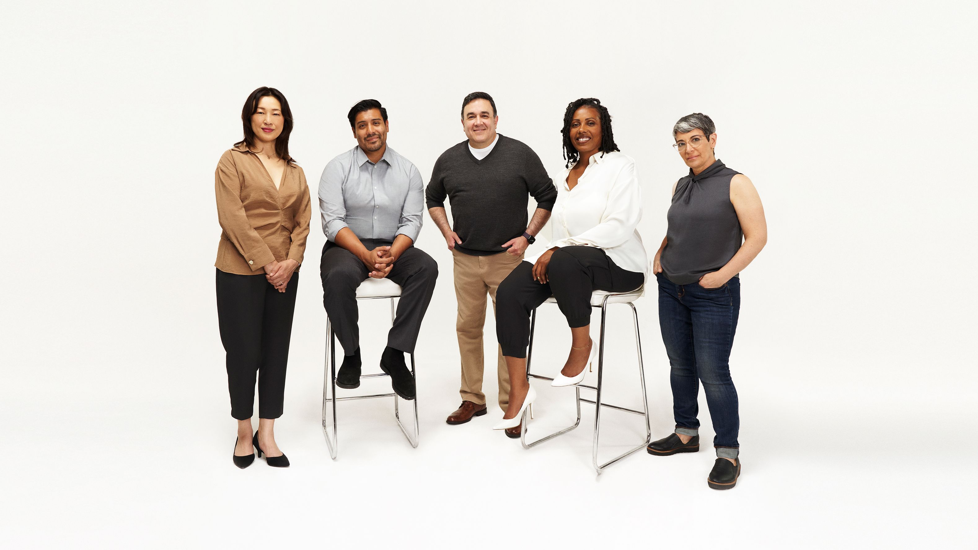 Team photo of five people in white background